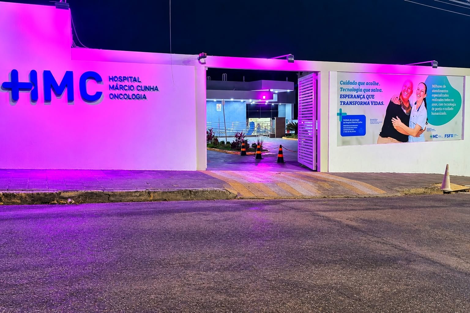 Fachada da unidade de Oncologia do Hospital Márcio Cunha iluminada de rosa, em alusão ao Outubro Rosa